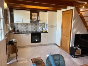 a kitchen with white cabinets and a stove at Pets Home by Oxyne in Louches