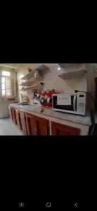 a kitchen with a microwave on top of a counter at La perle de Sétif in Sétif +7 photos