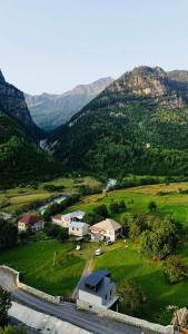 an aerial view of a house in a valley with mountains at Madisha's Guesthouse in Mestia
