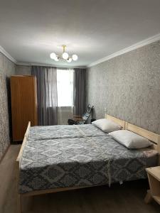 a bedroom with a large bed with a blue blanket at Mestia Central Apartment in Mestia