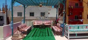 a balcony with chairs and a table on a building at Hana hostel not for Egyptian in Hurghada