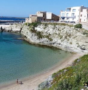a group of people on a beach near the water at Sabry holiday Terrasini in Terrasini