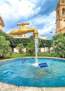a fountain in the middle of a swimming pool at Sabry holiday Terrasini in Terrasini