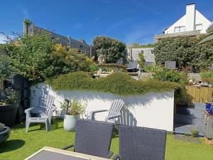 a garden with two chairs and a hedge at La Coccinelle Des Caps in Ambleteuse