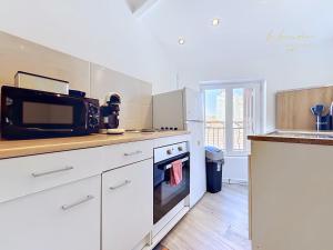 a kitchen with a microwave and a stove top oven at L'R du Temps 2 - Clim, Centre-ville, 6 personnes, 4 lits in Istres