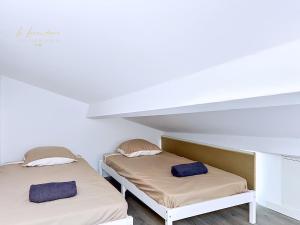 two beds in a room with white walls at L'R du Temps 2 - Clim, Centre-ville, 6 personnes, 4 lits in Istres