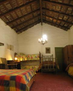 1 dormitorio con cama y lámpara de araña en La Casona del Río en Valle Hermoso