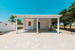a large patio with a white pavilion at Baglivi's Flat in Torre Specchia Ruggeri