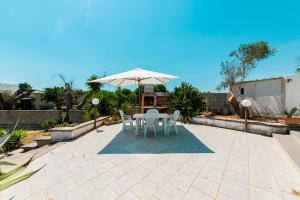 a patio with a table and an umbrella at Baglivi's Flat in Torre Specchia Ruggeri