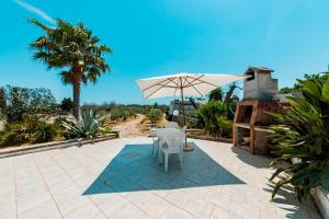 a patio with a table and an umbrella at Baglivi's Flat in Torre Specchia Ruggeri