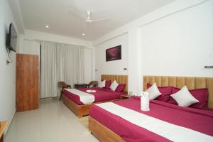 a hotel room with two beds and a television at The Great Hill View Hotel in Phata