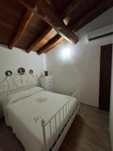 a bedroom with a white bed and a wooden ceiling at KaraA'mare in San Teodoro