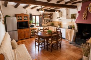 a kitchen with a table and chairs and a refrigerator at Cal Gironell in Santa María de Meyá +23 photos