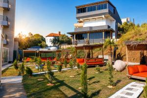 a house with a yard with orange furniture and trees at Grand Rimedya Hotel in Karabağ