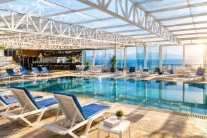 a large swimming pool with chairs at Grand Rimedya Hotel in Karabağ
