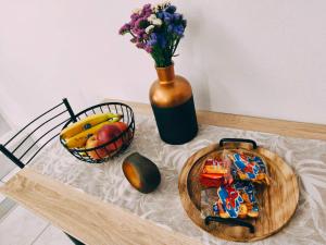 a table with a bowl of fruit and a vase with flowers at Sofia in Komotini +24 photos
