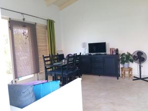 a living room with a table and chairs and a television at Caribbean Court E1 in Kralendijk