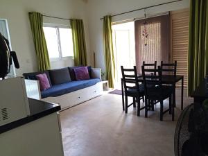 a living room with a couch and a table and chairs at Caribbean Court E1 in Kralendijk