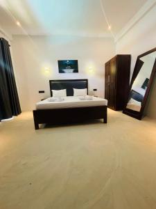 a bedroom with a bed and a tv on the wall at Surf Arugam in Arugam Bay