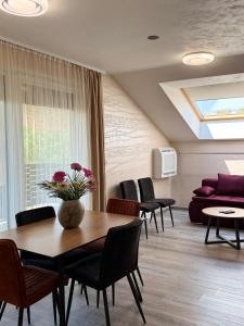 a living room with a table and chairs and a couch at Villa Moste Ljubljana - Modern apartments with Pool, EV station & free parking in Ljubljana