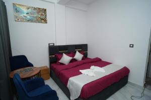 a bedroom with a bed and a blue chair at The Great Hill View Hotel in Phata +18 photos