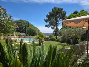 a garden with a swimming pool and trees at CÉRÈS - Boutique-Hôtel & Spa - Élégance en Terre d'Uzès in Saint-Quentin-la-Poterie
