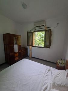 a bedroom with a large white bed and a window at Quinta de 4 Pilares in Canavial