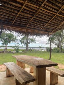 two wooden benches sitting under a pavilion at Foresta Yala in Tissamaharama +44 photos
