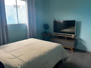 a bedroom with a bed and a flat screen tv at Loft Sousas in Campinas