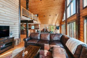 a living room with a leather couch and a television at Red Tara Sanctuary in Catskill