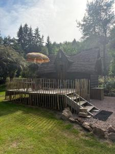 a wooden fence in front of a house with an umbrella at La cabane de Moïra in Xertigny