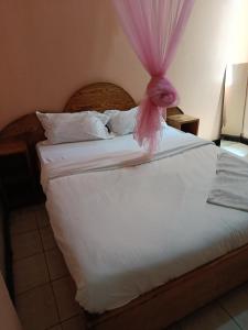 a bed with a pink bow on top of it at City Brisa cbd in Nairobi