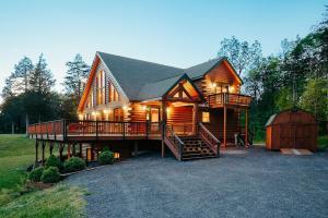a large wooden house with a large deck and a garage at Red Tara Sanctuary in Catskill