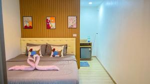 a bedroom with a bed with two snakes on it at มาแคมป์ ชะอม in Ban Bung Mai +5 photos