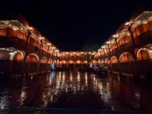 an empty building with lights on the water at night at Hotel Estancia Bugambilias in San Diego de la Unión