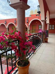 a balcony with pink flowers in a building at Hotel Estancia Bugambilias in San Diego de la Unión
