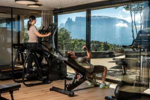 un uomo seduto su una sedia in una palestra di Hotel Lichtenstern a Soprabolzano