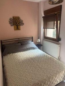 a bedroom with a bed and a tree picture on the wall at Sofia in Komotini