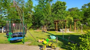 a playground with a bike and a swing at Apartmani Eli SA DVORIŠTEM in Veliko Gradište