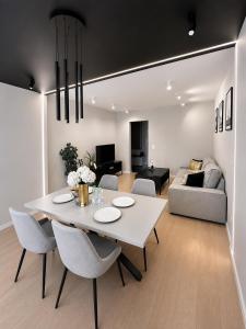 a dining room and living room with a white table and chairs at Apartment BEIGE Exclusive in Piekary Śląskie