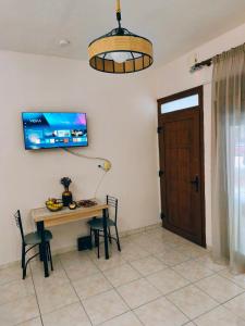 a dining room with a table and a television on the wall at Sofia in Komotini