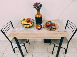 a table with a bowl of fruit and a vase of flowers at Sofia in Komotini