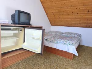 a small bedroom with a small bed and a tv at Pension V Doubí in Slavče