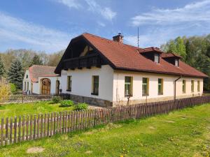 a white house with a brown roof and a fence at Pension V Doubí in Slavče