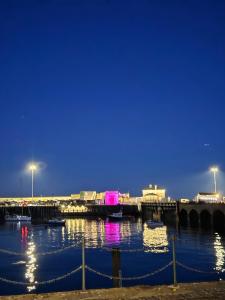 a pier with boats in the water at night at The Coastal Nest in Folkestone