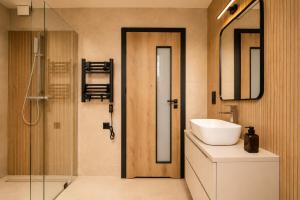 a bathroom with a sink and a mirror and a shower at SenWood House in Zubrzyca Dolna +35 photos