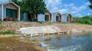 a row of houses next to a body of water at มาแคมป์ ชะอม in Ban Bung Mai