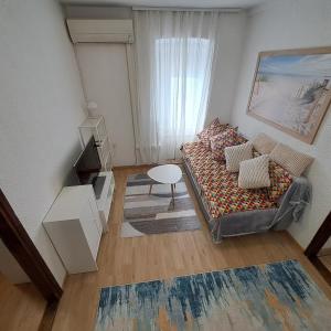 a small living room with a couch and a table at E & E apartment in Koper