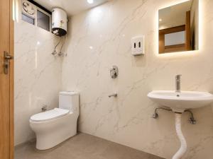 a white bathroom with a toilet and a sink at Hotel Devi Ram Atithi Bhawan Near Banke Bihari Mandir in Vrindāvan
