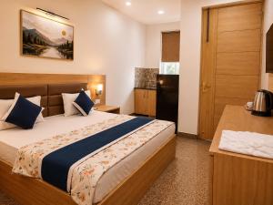 a bedroom with a large bed with blue pillows at Hotel Devi Ram Atithi Bhawan Near Banke Bihari Mandir in Vrindāvan +14 photos